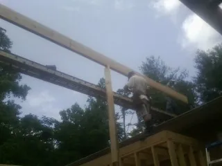 Carpenter setting a ridge beam over a new addition frame — Ice Dam Removal by Roofing Brothers in Warrior