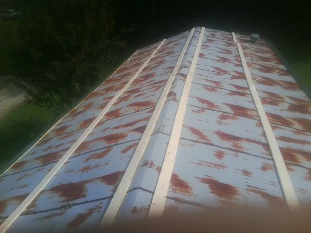 Rusted metal roof panels with new wood purlins before replacement — Storm Damage Roof Repair in Warrior by Roofing Brothers