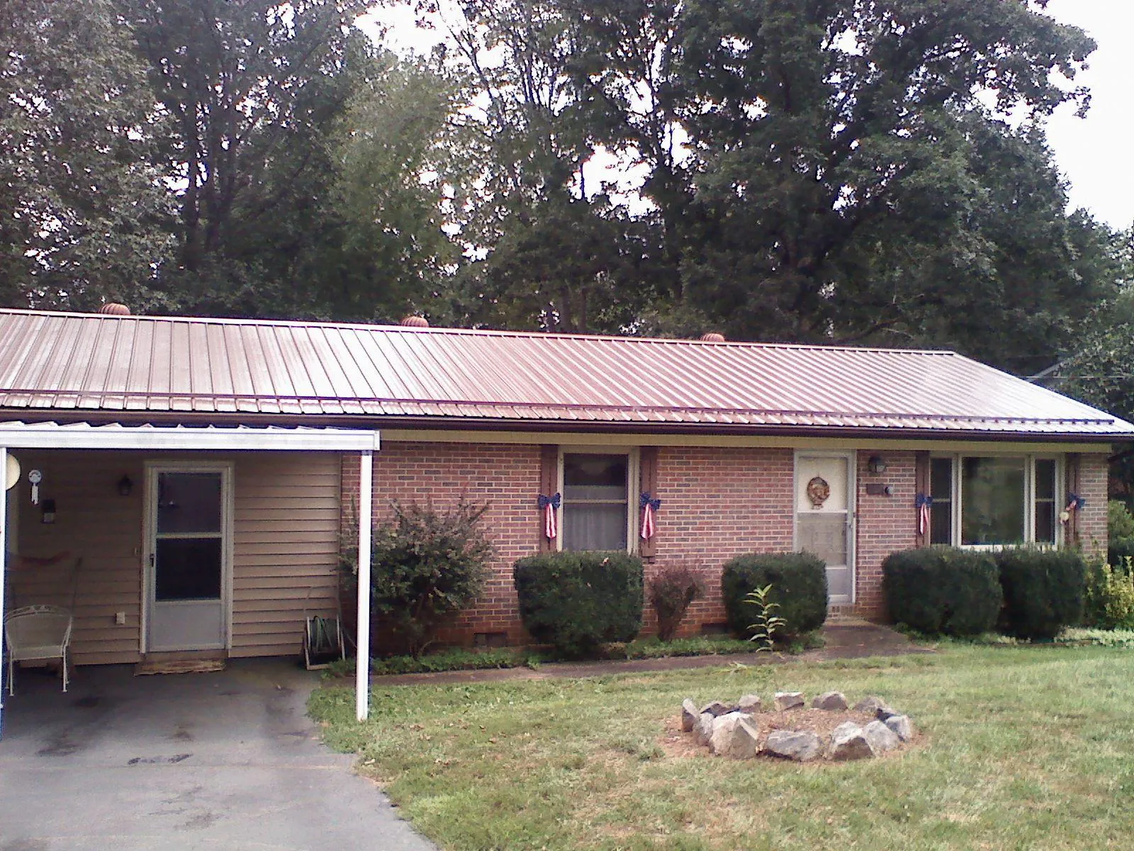 Bronze metal roof and carport on a brick ranch home — Roof Repair work by our crew in Warrior